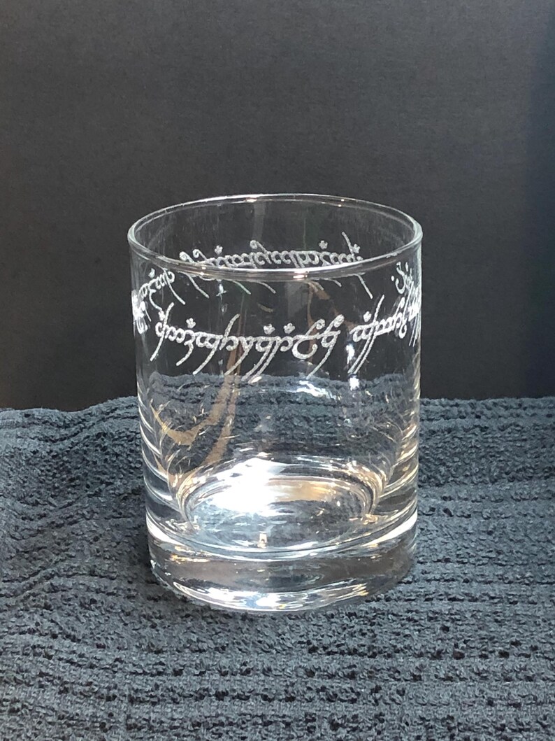 May include: A clear glass tumbler with the inscription "One Ring to rule them all, One Ring to find them, One Ring to bring them all and in the darkness bind them" etched around the side.