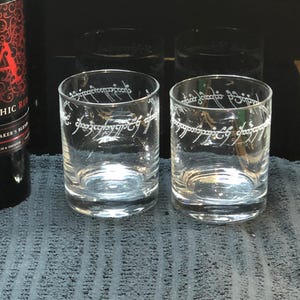 May include: Two clear glass tumblers with the inscription "One Ring to rule them all, One Ring to find them, One Ring to bring them all and in the darkness bind them" etched around the top of each glass.