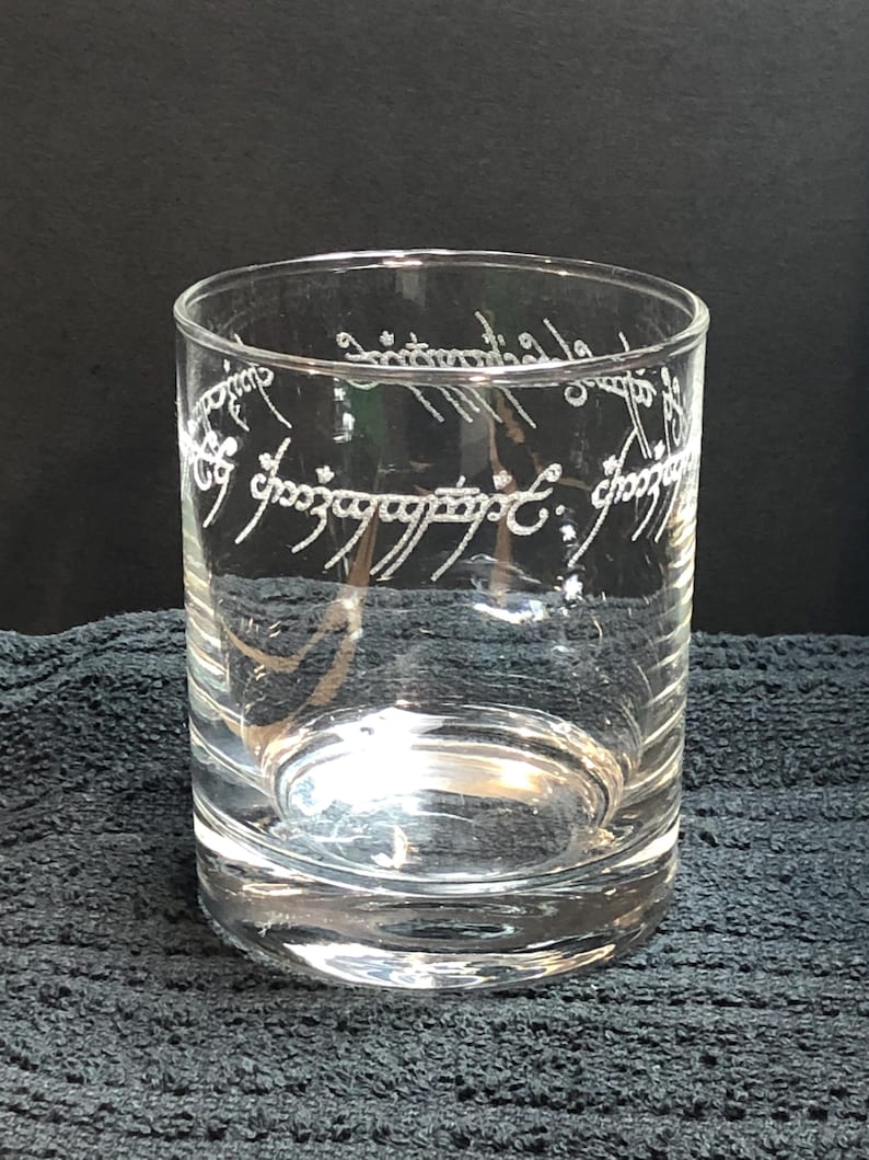 May include: A clear glass tumbler with the inscription "One Ring to rule them all, One Ring to find them, One Ring to bring them all and in the darkness bind them" etched around the top.