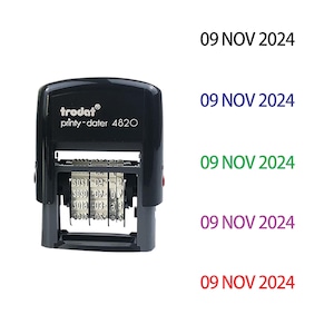 May include: A black Trodat printy-dater 4820 stamp displaying the date "09 NOV 2024" in different colours. The stamp has a rectangular shape and is shown with multiple impressions.