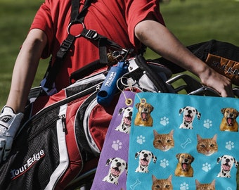 May include: A golfer carries a black and red golf bag with a purple and blue patterned golf towel attached. The towel features images of dogs and cats.