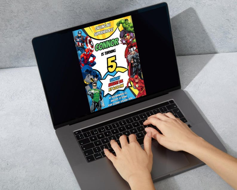 May include: A laptop displays a colorful birthday invitation featuring various superheroes. The invitation reads "Calling All Superheroes! Connor is turning 5" with event details. The laptop is open, and hands are typing on the keyboard.