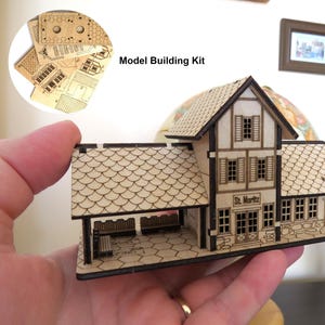 Puede incluir: Un kit de construcción de maquetas de madera de una estación de tren con un letrero que dice "St. Moritz". El kit incluye instrucciones detalladas y piezas cortadas con láser.