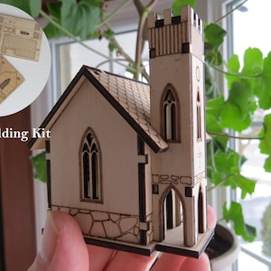May include: A wooden model church kit with a tall steeple. The kit includes pre-cut wooden pieces and the text "Model Building Kit". The church features arched windows and a stone-effect base.