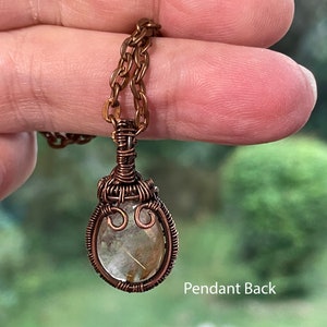 Small rutilated quartz pendant with woven wire setting with copper chain shown from the back