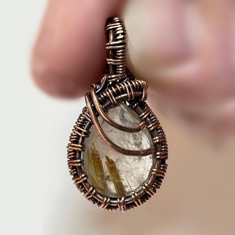 Small rutilated quartz pendant with woven wire setting.
