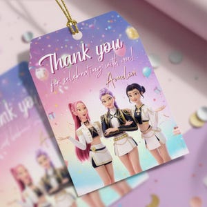 K&ouml;nnte beinhalten: Ein Geschenkanh&auml;nger mit einem lila-rosa Farbverlauf. Der Anh&auml;nger tr&auml;gt den Text "Thank you for celebrating with me! Amelia" in Schreibschrift. Drei Cartoon-Frauen sind auf dem Anh&auml;nger abgebildet. Der Anh&auml;nger ist mit einer goldenen Kordel versehen.