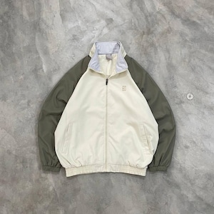 Peut inclure: Veste zipp&eacute;e cr&egrave;me avec des manches vert olive et un col gris clair. La veste pr&eacute;sente un petit logo sur la poitrine et deux poches avant. La veste a des poignets et un ourlet &eacute;lastiques.