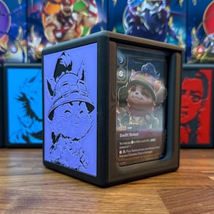 Puede incluir: Un tarjetero negro con una imagen en relieve púrpura de un personaje de dibujos animados en un lado y una tarjeta con el texto "Swift Scout" visible en el otro. El tarjetero está diseñado para proteger y exhibir tarjetas coleccionables.