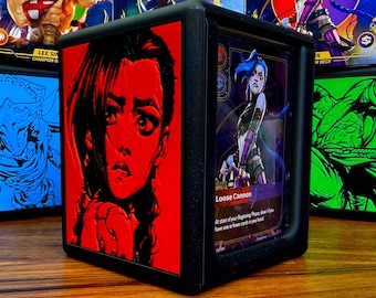 May include: Black display case featuring a red graphic of a character's face. The case holds a card with a character illustration and the text "Loose Cannon". Other cards with character art are visible in the background.