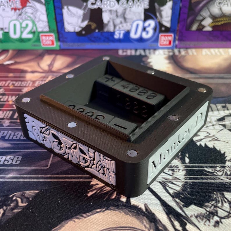 May include: Black dice tray with a raised edge and a compartment for dice. The tray has a white label on the side that says "Monkey D".