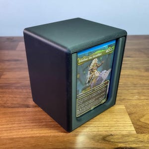 May include: A black card storage box with a single card visible. The card is a Magic: The Gathering card featuring a character named "Felothar the Steadfast".
