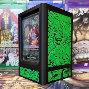 May include: Black card display case with green embossed anime character art. The case holds a trading card featuring a character named Jewelry Bonney. The case has a black frame and green accents, with the text "5000" visible on the card.