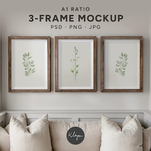 May include: A1 ratio 3-frame mockup PSD PNG JPG featuring three vertical wooden frames with white mats. Each frame displays a watercolor botanical illustration of green leaves on a light background, arranged in a horizontal row.