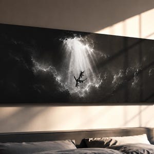 Pode incluir: Uma impressão de arte de parede retangular panorâmica apresentando uma cena em preto e branco de uma criatura alada em silhueta contra um céu escuro e nublado. Um feixe de luz vertical e brilhante desce de cima, iluminando o centro.