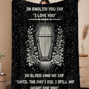 May include: Black and white throw blanket with a coffin and floral design. The text reads "In English you say "I love you" In elder emo we say "Until the day I die, I spill my heart for you."