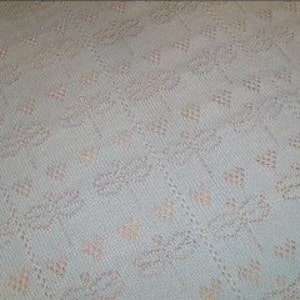 May include: A light blue crocheted blanket with a delicate floral pattern in a lighter shade of blue.