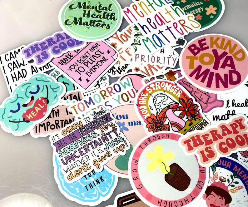 May include: A collection of colorful stickers with various motivational and mental health-related phrases. The stickers feature text like "Mental Health Matters," "Therapy is Cool," and "Be Kind to Your Mind," along with floral and brain illustrations.