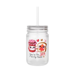 May include: White mason jar with a straw and a cute cartoon design of a jar of jam and a slice of toast. The text on the jar reads "You're the JAM to my toast".