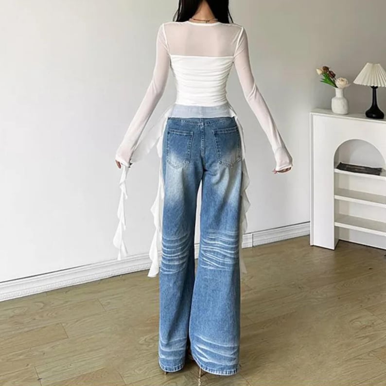 Women's Asymmetrical Mesh Tops | Long Sleeve Patchwork Shirt | Streetwear Y2k Chic Fashion

A fitted long sleeve top with cascading ribbon-like drapes extending at the sides, worn with wide-leg jeans. The piece has a structured upper silhouette and flowing layered accents for a dramatic, fashion-forward look.