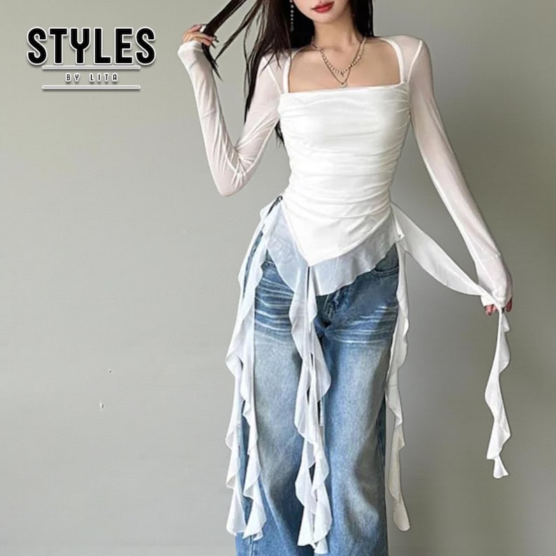 Women's Asymmetrical Mesh Tops | Long Sleeve Patchwork Shirt | Streetwear Y2k Chic Fashion

A fitted long sleeve top with cascading ribbon-like drapes extending at the sides, worn with wide-leg jeans. The piece has a structured upper silhouette and flowing layered accents for a dramatic, fashion-forward look.