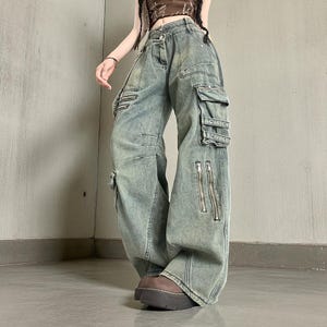 Baggy Cargo Pants | Streetwear Women Jeans | Wide Leg Style | Oversized Loose Pants
.
Women’s oversized cargo pants with wide-leg fit, buckle strap accents, zipper details, and multiple pockets styled in a Y2K streetwear look.
