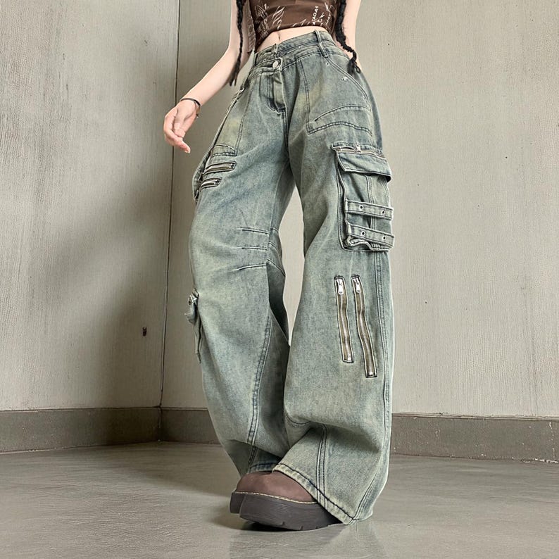 Baggy Cargo Pants | Streetwear Women Jeans | Wide Leg Style | Oversized Loose Pants
.
Women’s oversized cargo pants with wide-leg fit, buckle strap accents, zipper details, and multiple pockets styled in a Y2K streetwear look.