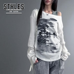 Puede incluir: Camiseta blanca de manga larga con estampado gráfico en negro y gris. La camisa tiene una textura acanalada y un diseño asimétrico único. El texto "STYLES BY LITA" está en la esquina superior izquierda. El modelo lleva vaqueros grises.