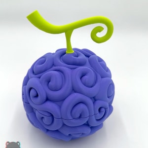 May include: A 3D-printed, purple, spherical object with a swirling pattern, topped with a green stem and curly tendril. The object is likely a replica of a fictional fruit. The base has a seam running around the middle.