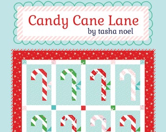 May include: A quilting pattern called "Candy Cane Lane" by Tasha Noel. The pattern features a grid of nine candy canes in red, green, and pink on a light blue background. The text "a fat eighth friendly pattern" and "#509" are at the bottom of the image.