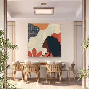 May include: A colorful abstract art print featuring a woman's silhouette with a blue, orange, and red background. The print is hanging on a white wall in a dining room with wooden chairs and a wooden table.