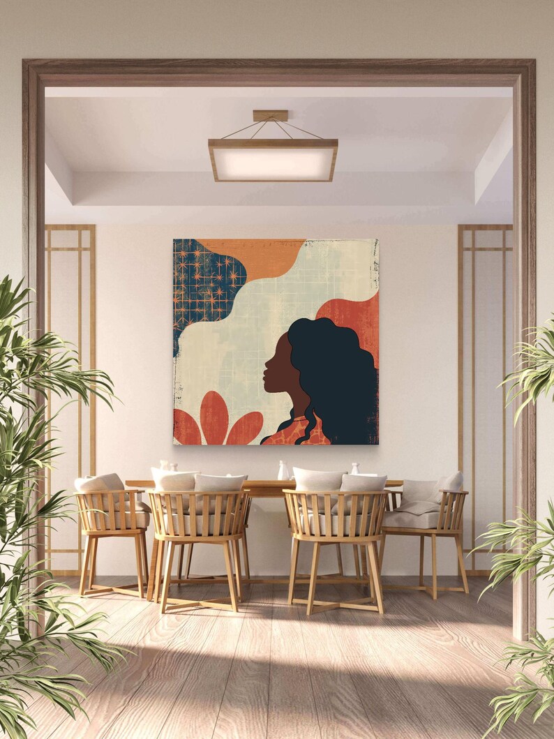 May include: A colorful abstract art print featuring a woman's silhouette with a blue, orange, and red background. The print is hanging on a white wall in a dining room with wooden chairs and a wooden table.