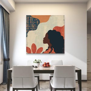 May include: Abstract art print featuring a woman's profile with a colorful background of red, orange, blue, and white. The print is hanging on a white wall above a dining table with two chairs.