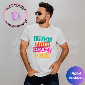 May include: White t-shirt with the text "TRUST YOUR CRAZY IDEAS" in colourful rectangular boxes. The text is in a distressed font.