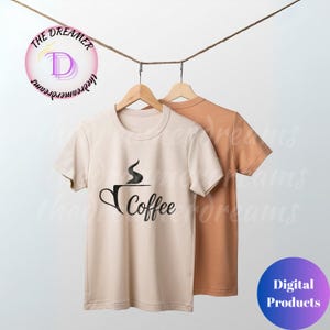 May include: Two t-shirts hanging from a rope. The first is beige with a black coffee cup graphic and the word "Coffee". The second shirt is a solid orange color. The logo "The Dreamer" is in the upper left corner.
