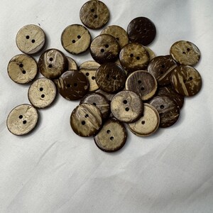 May include: A pile of brown and tan coconut shell buttons with four holes each.