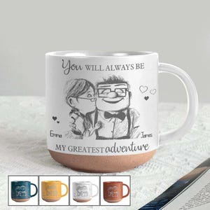 May include: White ceramic mug with a brown base, featuring a black and white illustration of a couple and the text "You will always be MY GREATEST adventure." Includes a white handle and a selection of colored mugs at the bottom.