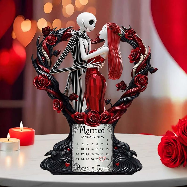 Puede incluir: Una figura decorativa con Jack Skellington y Sally de The Nightmare Before Christmas, abraz&aacute;ndose dentro de un marco en forma de coraz&oacute;n adornado con rosas rojas. La base incluye un calendario para enero de 2025, con la palabra "Married" y los nombres "Michael & Emma".