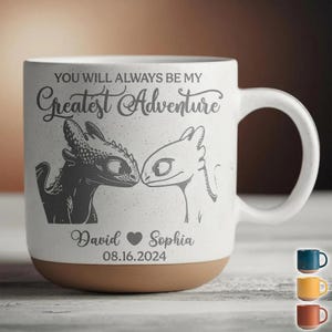 Può includere: Tazza in ceramica bianca con base marrone, con un'illustrazione di drago e la scritta "YOU WILL ALWAYS BE MY Greatest Adventure." Include i nomi "David" e "Sophia" con un cuore e la data 08.16.2024.