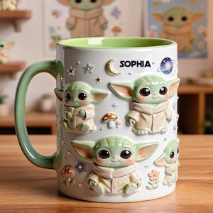 May include: A white ceramic mug with a light green interior and handle, featuring raised 3D-style illustrations of green creatures with large eyes, mushrooms, stars, a crescent moon, and a planet. The name SOPHIA is printed in dark blue text.