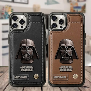 Puede incluir: Dos fundas de teléfono de cuero, una negra y otra marrón, cada una con un diseño de casco de Darth Vader. Las fundas tienen un tarjetero y el logo de Star Wars. El nombre "MICHAEL" está impreso en cada funda.