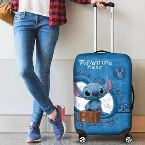 Puede incluir: Una maleta azul con ruedas con un personaje de dibujos animados y las palabras "Adventure Await". La maleta tiene un gr&aacute;fico de maleta marr&oacute;n y el nombre del personaje. Una persona con vaqueros azules y zapatillas azules sostiene la maleta.