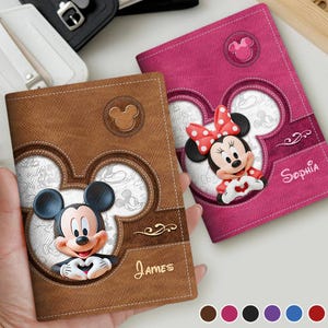 May include: Two personalised passport holders featuring Mickey and Minnie Mouse. One is brown with Mickey, the other is pink with Minnie. Both have a Mickey Mouse outline design and the names "James" and "Sophia" in gold lettering.