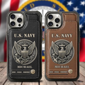 May include: Two leather phone cases, one black and one brown, featuring a U.S. Navy emblem. The cases have a cardholder design and are personalized with the name "MICHAEL" and the words "HONOR - COURAGE - COMMITMENT".