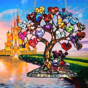 Puede incluir: Árbol de vidriera con hojas en forma de corazón de colores. El árbol presenta una pareja de ratones de dibujos animados sentados en un banco. La base del árbol dice "Anna & John YOU & ME WE GOT THIS". Un castillo y agua en el fondo.