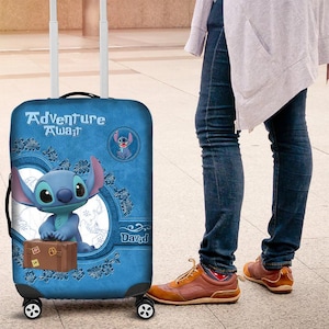 Puede incluir: Maleta rodante azul con Stitch de Lilo & Stitch. La maleta tiene las palabras "Adventure Awaits" y una imagen de dibujos animados de Stitch. Tambi&eacute;n tiene un gr&aacute;fico de maleta marr&oacute;n.