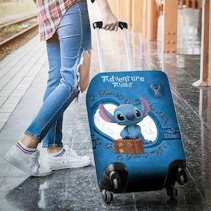 Puede incluir: Maleta con ruedas azul con el personaje Stitch de Lilo & Stitch. La maleta tiene las palabras "Adventure Awaits" y un peque&ntilde;o gr&aacute;fico de maleta marr&oacute;n. La maleta es tirada por una persona que lleva vaqueros azules y zapatillas blancas.