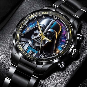 May include: Black wristwatch with a black metal band and a round face. The face features a Darth Vader graphic with a galaxy background. The watch face also has Roman numeral hour markers and a gold-colored second hand. The watch face also has the word "JAMES" printed on it.