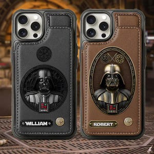 Może przedstawiać: Dwa skórzane etui na telefon z Darthem Vaderem. Jedno jest czarne z imieniem "WILLIAM", drugie brązowe z "ROBERT". Oba etui mają wytłoczony szczegółowy wizerunek Dartha Vadera.