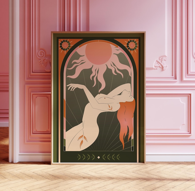 May include: A framed art print featuring a stylized illustration of a nude figure with flowing red hair, set against a dark green background. A peach-colored sun and decorative elements frame the figure. The artwork is in a wooden frame.